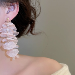 Detail view of pink chiffon flower earrings with pearls and long tassels on model