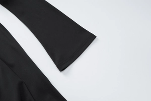 Détail de la couture sur la manche élastique noire de cette robe ajustée à manches longues