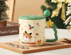 Close-up of ceramic Christmas mug with elk pattern, green lid and star-handle spoon