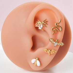 Boucles d'oreilles dorées serpent, chauve-souris et abeille sur modèle d'oreille