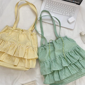 Detail view of plaid tote bags with ruffle trim in yellow and green colors