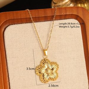 Detailed view of golden flower pendant necklace with size specs on rustic linen