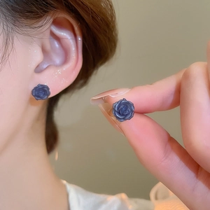 Détail macro de boucles d'oreilles roses en résine bleue avec pétales et design 3D