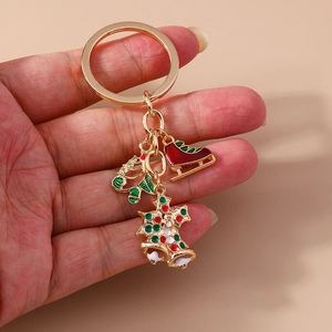 Detailed shot of Christmas keychain with enamel charms of a sleigh, skate and tree