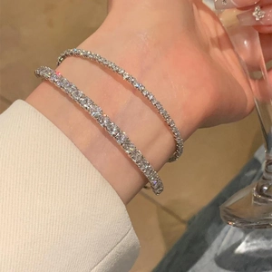 Détail de bracelets tennis argentés sertis de diamants superposés sur le poignet
