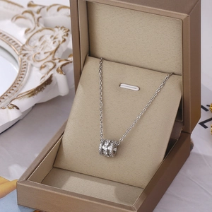 Collier argenté avec pendentif cylindrique serti de cristaux en boîte à bijoux