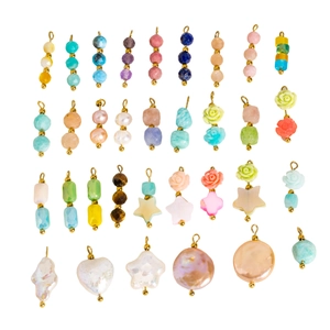Variety of natural stone and baroque pearl charms with gold loops on white background