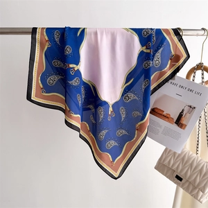 Detail of silk-feel scarf featuring blue paisley patterns and a stylish belt buckle design