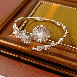 Detail view of vintage silver flower bracelet with pearls and zircons on green velvet