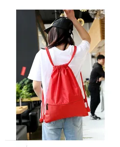 Red nylon drawstring backpack with waterproof texture and a bottom zipper pocket detail