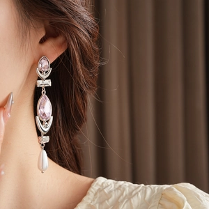 Detail of elegant silver drop earrings with pink crystals and a white waterdrop pearl