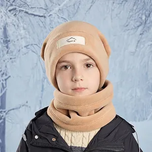 Beige fleece winter hat and neck warmer set for kids with sport patch in snow forest