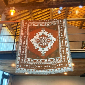 Close-up of bohemian woven blanket featuring geometric patterns and caramel fringe