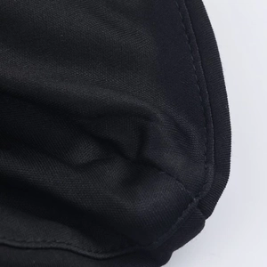 Close-up of black knit fabric featuring detailed overlock stitching and fine textile texture