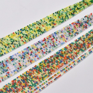 Macro detail of three 2mm multi-color faceted crystal bead strands for DIY jewelry making