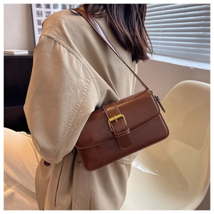 Detail view of brown vintage oiled leather crossbody bag with elegant gold buckle