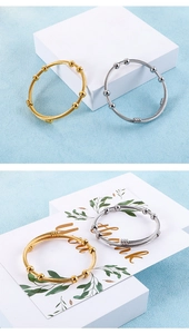 Détail de bracelets joncs torsadés en finition or et argent sur un présentoir