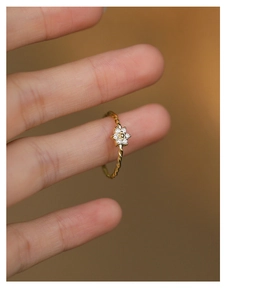 Detail of gold flower ring with micro-set zircon and unique twisted rope band texture