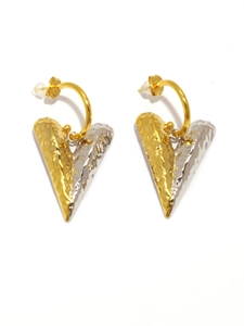 Macro detail of heart-shaped mixed metal earrings with textured gold and silver finish
