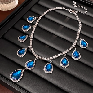 Detailed macro view of blue teardrop pendants and sparkling diamond link chain necklaces