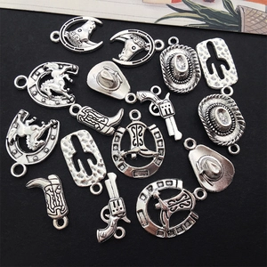 Macro detail of vintage silver alloy charms featuring cowboy hats and western motifs