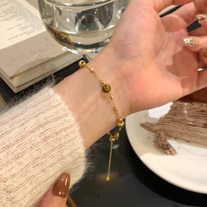 Detailed view of 18K gold plated beaded bracelet with tiger eye stone on a female wrist