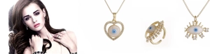 Details des vergoldeten Evil Eye Schmucksets mit Herzanhängern und Strassringen am Model