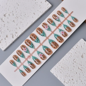 French almond press-on nails with leopard print and 3D floral accents on turquoise base