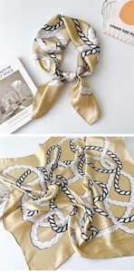 Close-up of luxury silk scarf with golden rope pattern and elegant smooth fabric texture