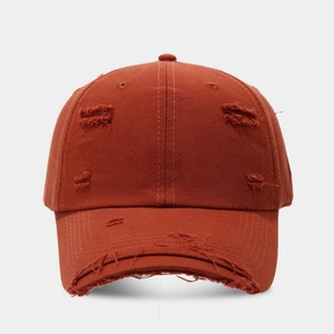 Detailed close-up of distressed cotton canvas and vintage ripped holes on the baseball cap