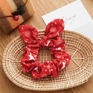 Detail of red Christmas scrunchie with snowflake and reindeer patterns on a tray