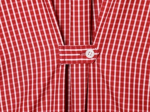 Close-up of red and white gingham poplin fabric with a white resin button detail