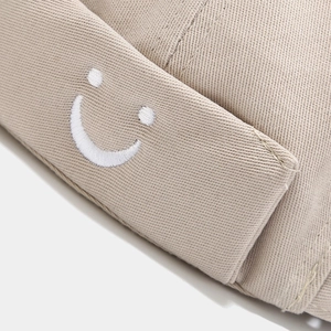 Unisex khaki brimless docker hat featuring detailed white smiley face embroidery