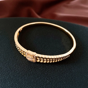 Gros plan d'un bracelet doré 18K avec boucle en zircon rectangulaire et détails de chaîne