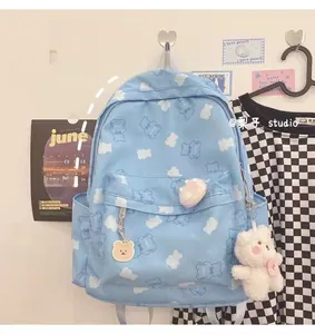 Close-up of light blue Harajuku backpack featuring white bear prints and plush pendant