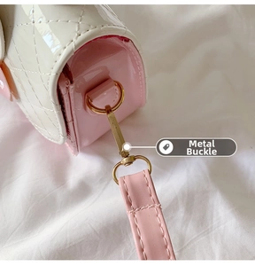 Close-up of the golden metal clasp and pink shoulder strap on the quilted girls bag