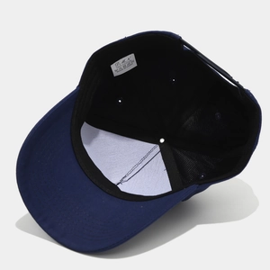 Détail intérieur d'une casquette trucker en coton bleu avec réglage snapback et étiquette