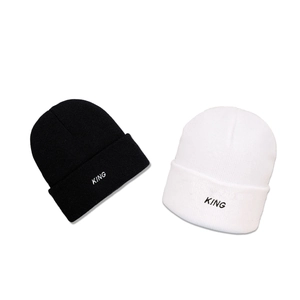 Black and white knit beanie hats with KING embroidery in a minimalist winter style