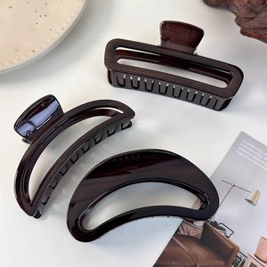 Macro detail of large tortoiseshell acrylic hair clips with hollow crescent design