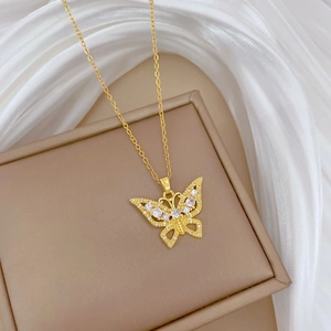 Elegant gold butterfly pendant necklace with crystal stones on white silk background
