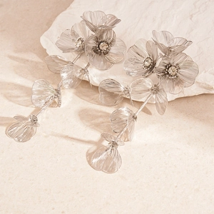 Detailed view of layered flower drop earrings with silver mesh petals and crystal centers