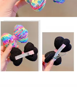 Detailed view of colorful sequined bow hair clip with sturdy metal duckbill clip back