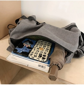 Top view of large gray canvas bag showing interior capacity with books and umbrella