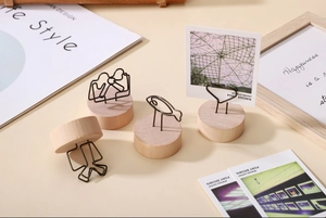 Détail de porte-notes en bois avec pinces métalliques de formes variées sur table