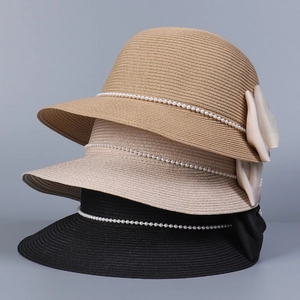 Détails de chapeaux de paille avec lanières en perles et grands nœuds en kaki et beige