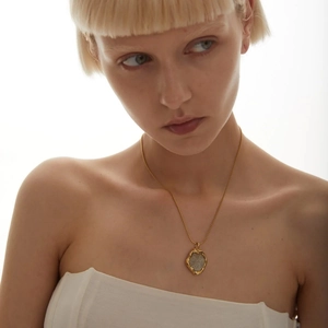 Elegant 18k gold plated brass necklace with vintage coin pendant worn by a model
