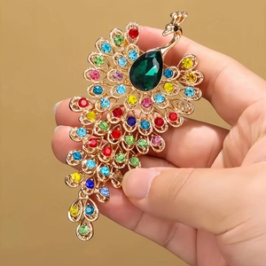 Elegant gold peacock brooch with multicolored crystals and a green teardrop stone