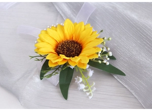 Detail of yellow sunflower wrist corsage with white pearls and silk ribbons for weddings