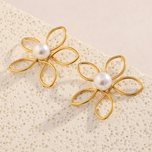 Gros plan de boucles d'oreilles fleurs en plaqué or 18K avec perles sur pierre