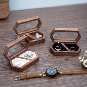 Detail view of hexagonal walnut wood jewelry box with magnetic flip glass lid and soft velvet liner